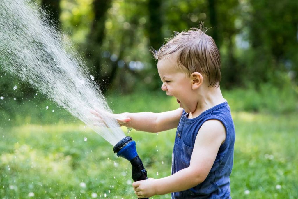 boy playing with garden hose